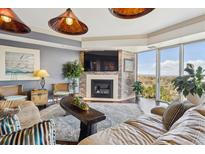 Bright living room features a brick fireplace, large windows, and scenic views at 1900 E Girard Pl # 907, Englewood, CO 80113