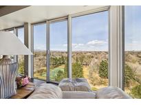 Bright living room with expansive windows offering scenic views of the landscape and distant city skyline at 1900 E Girard Pl # 907, Englewood, CO 80113