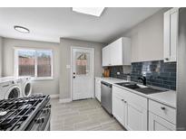 Well-lit kitchen with sleek, dark backsplash, stainless steel appliances, and tile flooring at 500 S Pennsylvania St # 520, Denver, CO 80209