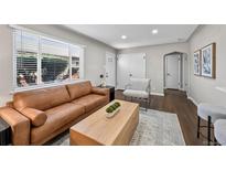 Bright living room featuring a leather sofa, modern decor, hardwood floors and abundant natural light at 500 S Pennsylvania St # 520, Denver, CO 80209