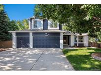 Charming two-story home featuring a three-car garage and a well-maintained front yard with mature tree at 9924 Silver Maple Way, Highlands Ranch, CO 80129