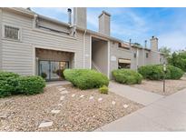 Inviting condo exterior featuring manicured landscaping and a charming stone pathway at 3600 S Pierce St # 5-101, Denver, CO 80235