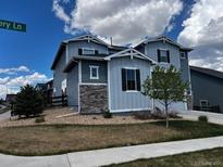 Charming two-story home with blue siding, stone accents, and a well-manicured lawn at 11821 Discovery Ln, Parker, CO 80138