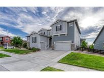 Inviting two-story home featuring a wide driveway, attached two-car garage and nicely manicured lawn at 11821 Discovery Ln, Parker, CO 80138