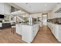 Bright, open kitchen with a large center island, stainless steel appliances, and hardwood floors at 11821 Discovery Ln, Parker, CO 80138