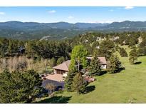 Expansive home with a three-car garage is surrounded by mature trees and offers stunning mountain views at 1621 Baneberry Ln, Golden, CO 80401