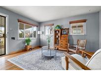 Cozy living room with a large area rug, wood floors, and vintage wooden furniture at 875 S Dale Ct, Denver, CO 80219