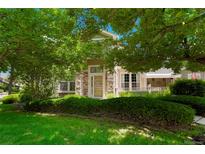 Charming home exterior with stone accents and lush landscaping providing shade at 5155 W Quincy Ave # 101, Denver, CO 80236