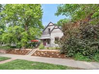 Charming two-story home with a mature tree, landscaped front yard, and inviting front porch area at 3254 Newton St, Denver, CO 80211