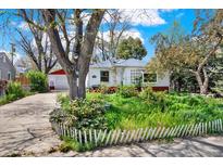 Charming single-story home with a beautiful front yard and a detached garage at 5211 Dover St, Arvada, CO 80002