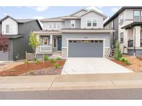 Charming two-story home with a gray exterior, a two-car garage, and a well-maintained front yard at 8582 Cheraw St, Littleton, CO 80125