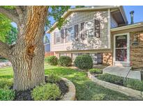 Charming home with a landscaped front yard, mature tree, and stone-edged flower beds at 4664 S Zang St, Morrison, CO 80465