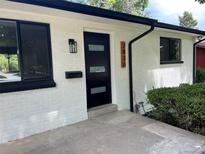 Close up of a modern front door on a painted brick home with updated fixtures at 2836 S Fenton St, Denver, CO 80227