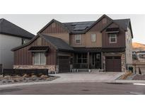 Two-story home with brown siding, stone accents, and solar panels at 15601 W Eureka Ave, Morrison, CO 80465