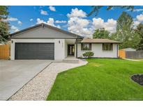 Charming single-story home featuring a large driveway, two-car garage, and inviting lawn at 8357 Dudley Ct, Arvada, CO 80005