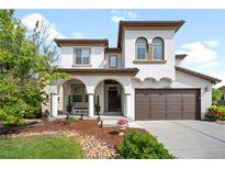 Stunning two-story home featuring a covered front porch, a two-car garage, and manicured landscaping at 15205 W Baker Ave, Lakewood, CO 80228