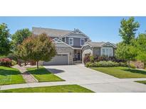 Charming two-story home features a well-manicured lawn, mature landscaping, and a spacious three-car garage at 8677 S Buchanan Way, Aurora, CO 80016