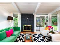Bright living room featuring a sleek fireplace, modern furniture, and access to the outdoor garden through sliding glass doors at 1831 S Ivanhoe St, Denver, CO 80224