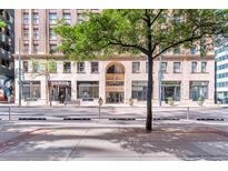 Street view of condo building with stone facade, large windows, and street access at 444 17Th St # 1003, Denver, CO 80202