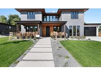 Stunning modern home with a gray brick exterior, wooden accents, and professional landscaping at 5358 Lions Paw St, Castle Rock, CO 80104