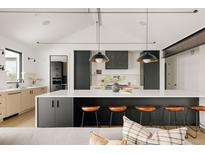 Modern kitchen featuring a large island with seating, sleek cabinets, and stylish pendant lighting at 5358 Lions Paw St, Castle Rock, CO 80104