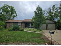 Charming ranch-style home featuring mature trees, brick accents, and a well-manicured lawn at 912 E 6Th Ave, Broomfield, CO 80020