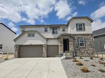 Charming two-story home with stone accents, a three-car garage, and professionally landscaped front yard at 5629 Farrier Pt, Castle Rock, CO 80104