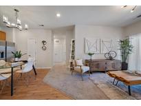 Open-concept living area with stylish decor and a view of the kitchen and dining area at 1841 S Dunkirk St # 203, Aurora, CO 80017