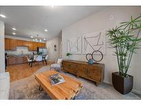 Inviting living room featuring modern decor, stylish furniture, and an open layout with a view of the kitchen and dining area at 1841 S Dunkirk St # 203, Aurora, CO 80017