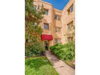 Charming apartment building entrance with red awning and mature landscaping at 1100 Colorado Blvd # 305, Denver, CO 80206