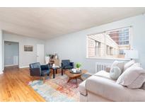 Bright living room with hardwood floors, comfortable seating, and a colorful area rug at 1100 Colorado Blvd # 305, Denver, CO 80206