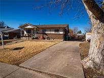 Cozy single-story home with brick accents, a long driveway, and mature trees, perfect for suburban living at 871 S Worchester St, Aurora, CO 80012
