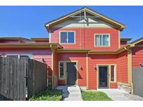 Charming red two-story townhome featuring well-kept landscaping and complementary architectural details at 1775 Aspen Meadows Cir, Denver, CO 80260