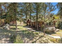 Charming log cabin with natural landscaping and mature trees at 25728 Stanley Park Rd, Evergreen, CO 80439