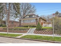 Charming brick home with well-maintained lawn, a retaining wall, and inviting stairway to the front door at 1230 S Emerson St, Denver, CO 80210