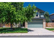 Two-story home featuring a front-facing two car garage, mature landscaping, and a brick facade at 20445 Mitchell Pl, Denver, CO 80249