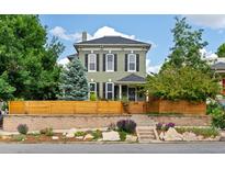 Charming two-story home with a landscaped front yard and a wooden fence, perfect for curb appeal at 2098 N Clarkson St, Denver, CO 80205
