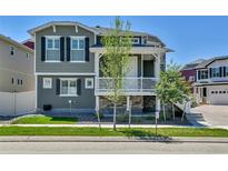 Charming two-story home featuring gray siding, black shutters, and a welcoming front porch at 1086 Highlands Dr, Erie, CO 80516