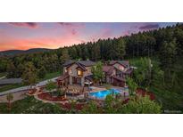 Stunning home with a pool, hot tub, and forest views, offering luxury and serenity at 12555 Critchell Ln, Littleton, CO 80127