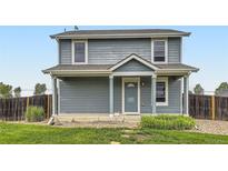 Charming two-story home with a covered front porch and a well-maintained lawn at 2707 Quarterland St, Strasburg, CO 80136