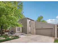 Two-story home with a deck, two-car garage and a combination of stone and wood siding at 1582 W Briarwood Ave, Littleton, CO 80120
