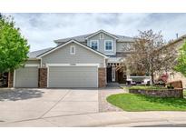 Charming two-story home featuring a three car garage, landscaped yard, and stone accents at 22898 Addington Pl, Parker, CO 80138