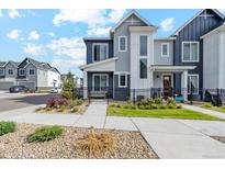 Charming two-story home with a well-maintained lawn, landscaped with plants, and a black metal fence at 1954 S Poplar Ct, Denver, CO 80224