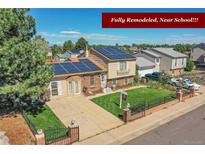 Charming home featuring solar panels, landscaped yard, and a brick-accented facade at 5183 Durham Ct, Denver, CO 80239