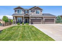 Two-story house with a large front yard, driveway, and attached two-car garage at 8939 Devinney Ct, Arvada, CO 80005