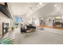 Bright living room boasts large windows, fireplace, and open floor plan to dining area at 2609 S Quebec St # 9, Denver, CO 80231