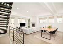 Bright and airy living room features an open floor plan, modern fireplace and staircase with metal railings at 1945 W 34Th Ave, Denver, CO 80211