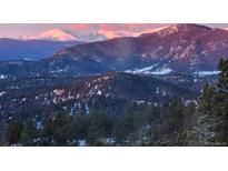 A stunning vista of snow-capped mountains in a winter landscape at 26116 Chief Hosa Rd, Golden, CO 80401