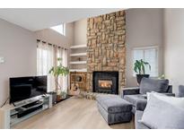 Inviting living room with a stone fireplace, modern furniture, bright windows, and neutral paint creating a warm atmosphere at 12430 E Pacific Cir # B, Aurora, CO 80014
