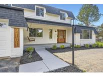 Charming two-story home with a front porch swing and a well-manicured lawn at 2101 Champlain Dr, Boulder, CO 80301